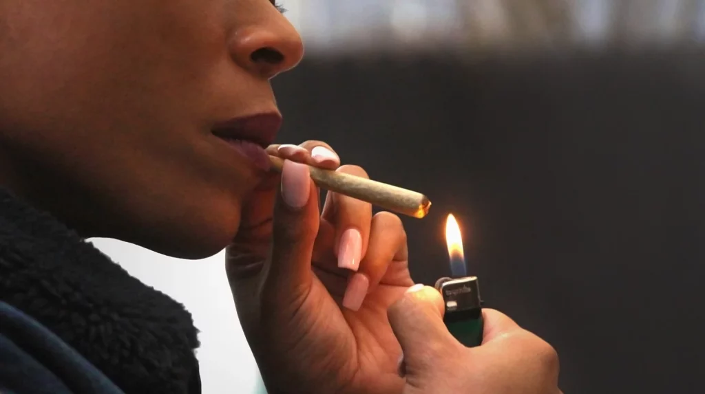 woman lighting a preroll